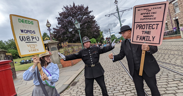 police man stands between Suffragette and protester holding plackards at Beamish Museum